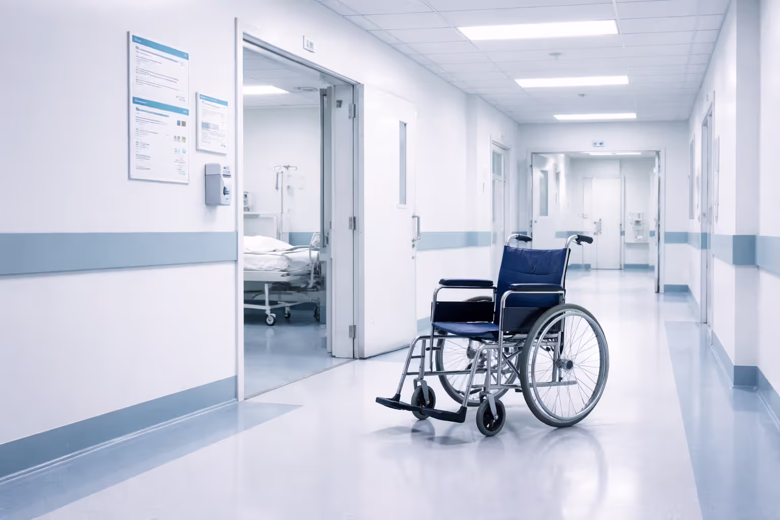 Empty hospital wheelchair in bright clinical hallway near open patient room door